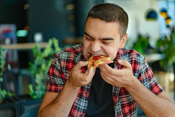 Мужчина Клетчатой Рубашке Ест Вкусную Пиццу Сыром Колбасой Соусом Ресторане — стоковое фото