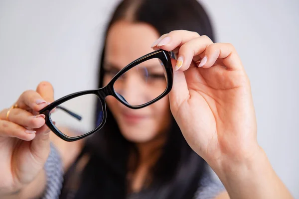 Kadın Tutar Gözlük Siyah Rim Ile Beyaz Bir Arka Plan — Stok fotoğraf