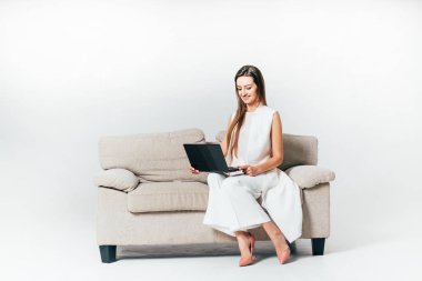 neşeli iş kadını koltukta oturur ve dizüstü ellerinin beyaz bir arka plan üzerinde tutar. Yakın çekim