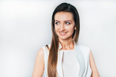 Beyaz elbiseli şık iş kadını tarafına stüdyoda beyaz bir arka plan üzerinde görünüyor. Bir iş kadını portresi. Yakın çekim