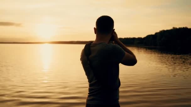 摄影师剪影在日出 河边美丽的夏日日落 — 图库视频影像