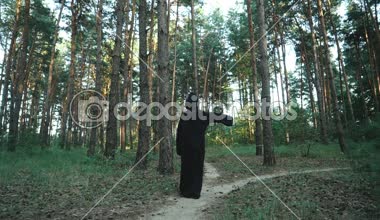 Siyah pelerin Halloween korku adam ormanda yürüyüş