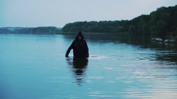 川でフード付き黒マントで邪悪な魔女 ハロウィーンの衣装 — ストック動画