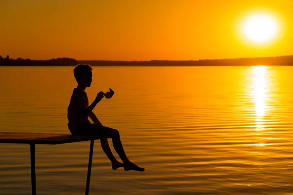 Ein Jugendlicher Sitzt Auf Dem Hölzernen Schiff Und Hält Hintergrund — Stockfoto