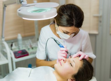 Profesyonel Şevval özçelik güzellik kadın yüzüne kaş dövme yapıyor. Kalıcı kaş makyaj güzellik salonu. Kozmetik tedavi.