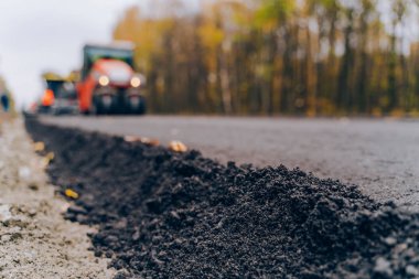 Yeni yol inşaat sitesinde görünümü kapat. Yakın çekim asfalt yol yapım aşamasında. Asfaltlama