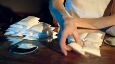 Daha fazla satış ve dağıtım için uyuşturucu dolu yeraltı laboratuarındaki Dağıtıcı Krupiye Yerlerinde Brick paketleri. Kriminal İş