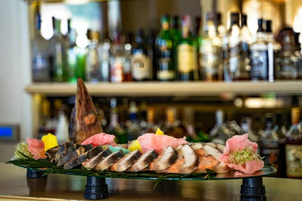 Big fish slices on fish-shaped plate near bar counter. Fresh cooked fish on a plate in the restaurant.