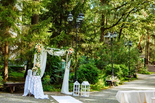 Beautiful wedding white ark decorated with flowers in the forest background in summer day. Wedding ark adorned with flowers in the natural background of forest.