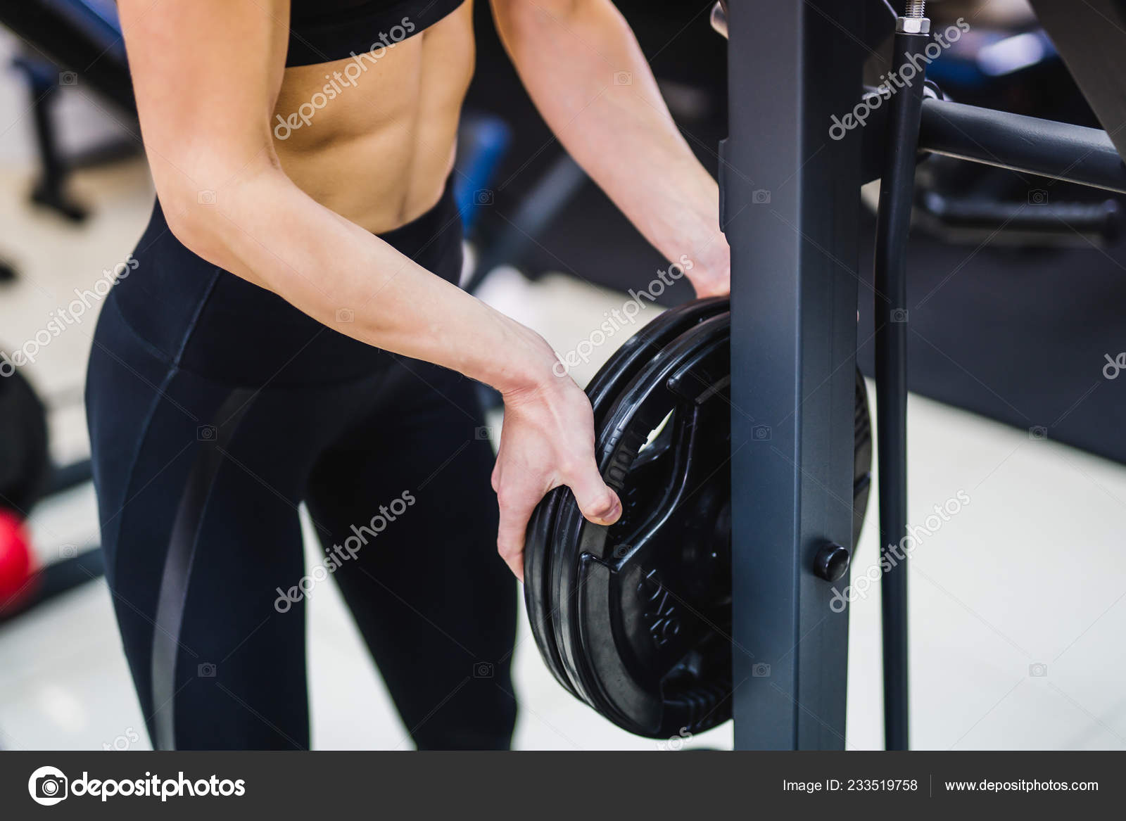 Chica sexy fitness joven se detiene en el gimnasio mujer morena fitness en  ropa deportiva negra con cuerpo perfecto fitness en el gimnasio, tirando de  ella en la barra horizontal