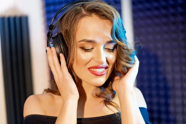 年轻美丽的女人的肖像与耳机听音乐 有吸引力的快乐的女性模型隔离在演播室 幸福理念 — 图库照片