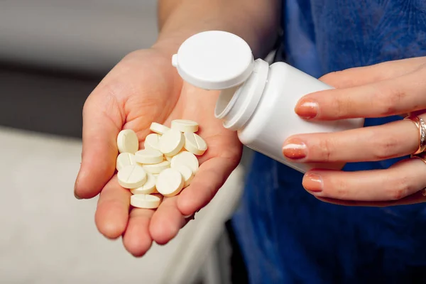 Vrouw Giet Witte Ronde Pillen Uit Kunststof Pot Haar Hand — Stockfoto