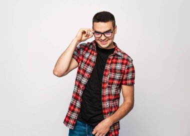 Yakışıklı delikanlı büyük gülümseme ile lots-in kopya alanı çerçevede moda gözlük takıyor. Gözlüklerini ayarlama ve kameraya bakarak mutlu erkek