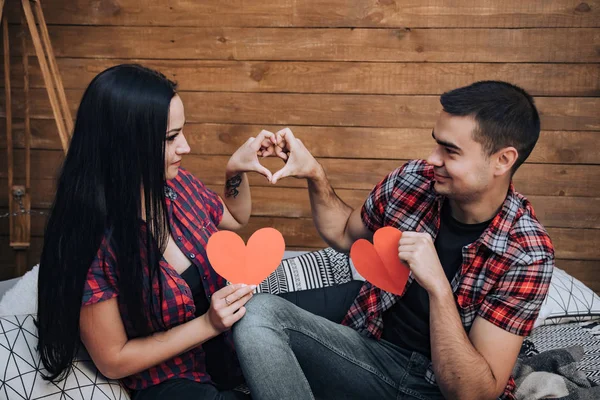 Bonita Pareja Enamorada Mirándose Sosteniendo Corazones Papel Rojo Sentados Cama — Foto de Stock