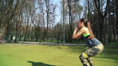 Atletik kadın kauçuk şeritler kullanarak stadyumda çalışma dışarı. Zor iş. Yaşam tarzı spor.