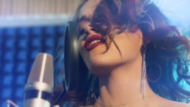 Kadının bir kayıt stüdyosunda şarkı. Bayan vokal. Profesyonel kayıt stüdyosu. Ağır çekim