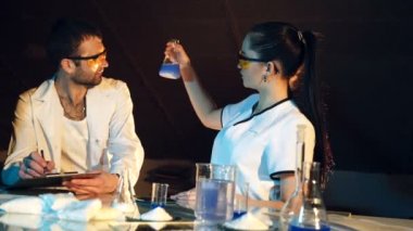 İki bilim adamları laboratuarda çalışıyoruz. Genç kadın araştırmacı ve onun üst düzey danışmanı test tüpleri ile araştırmalar yapıyoruz.