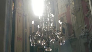 Lüks bir avize ortasında bir Katolik Katedrali freskler arka plan üzerinde asılı. Tarafa kamera hareket
