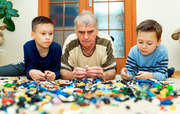 Starszy Mężczyzna Dwóch Chłopców Dobry Gra Mnóstwem Kolorowe Plastikowe Zabawki — Zdjęcie stockowe