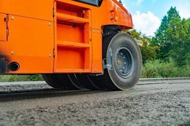 Turuncu yol silindiri kaldırım yapar. Yol inşaat sitesinde çalışan yol silindiri görünümü kapat. Yol makineleri