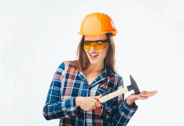 Mutlu erkek ile beyaz arka plan üzerinde izole çekiç ve turuncu koruyucu gözlük kask binada. Genç model kask ve gözlük.