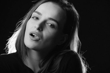 Seksi model açık ağızlı kameraya siyah arka plan üzerine arıyorum. Siyah ve beyaz fotoğraf kameraya benzeyen bir kız portresi. Yakın çekim