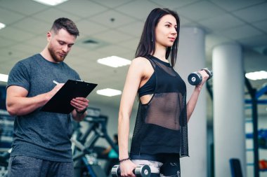 Spor salonunda fitness eğitmeni ile egzersiz fitness kadın. Kişisel fitness eğitmeni. Kişisel eğitim.