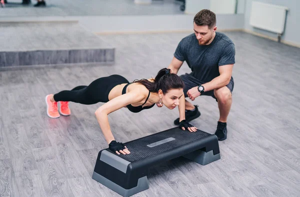 Mulher Atraente Fazendo Push Com Ajuda Instrutor Pessoal Isolado Fundo — Fotografia de Stock