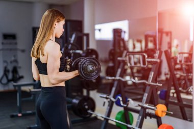Spor salonunda egzersiz genç seksi fitness eğitmeni. Halter salonunda ile egzersiz fitness kız