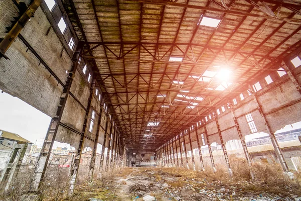 Innenraum des alten Fabrikgebäudes mit Löchern in Dach und Wänden zerstört. Industrieruinen, Trümmerteile zerbröseln in Fabrik als Folge der Wirtschaftskrise und des Erdbebens — Stockfoto