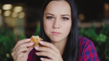 bir ekose gömlek güzel esmer iç arka planda kafede zevk ile pizza yiyor