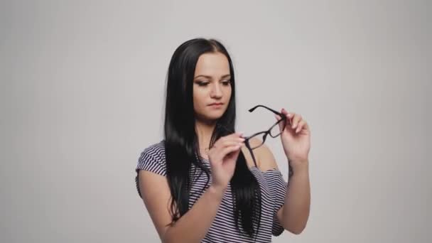 Brunette Robe Rayée Met Des Lunettes Sur Fond Gris — Video