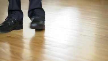 komik adam siyah ayakkabılar ve pantolon üzerinde kahverengi bir laminat dans ediyor