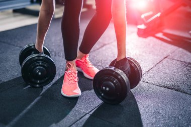 Spor Egzersiz Egzersizler dumbbells ile. Genç kadın fitness merkezinde eğitim