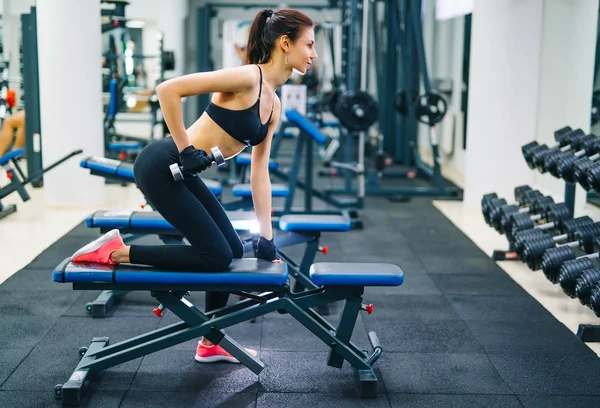 Athletische Frau, die mit Kurzhanteln Muskeln aufpumpt. Sport, Fitness und gesunder Lebensstil. — Stockfoto