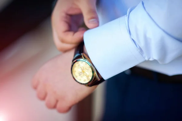 Hombre de negocios comprobando la hora de su reloj de pulsera, hombre poniendo el reloj en la mano. Novio preparándose en la mañana antes de la ceremonia de boda — Foto de Stock