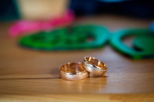 Primer plano de los anillos de oro de la boda para la novia y el novio en el fondo borroso. Accesorios de boda. Detalles de boda — Foto de Stock