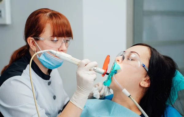 Dentista feminina tratando os dentes da paciente — Fotografia de Stock