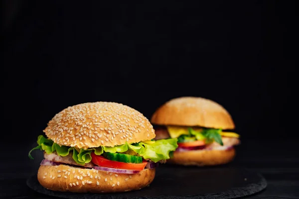 Hambúrguer saboroso com legumes frescos na mesa — Fotografia de Stock
