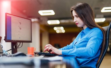 Modern ofiste bir bilgisayar üzerinde çalışan yazılım geliştiricisi. Güzel genç kadın programlama bilişim şirketinde gelişen teknolojiler. Yüksek kaliteli görüntü.