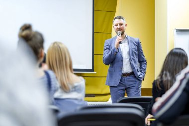 Kürsüde hoparlör. Konferans salonundaki insanlar. Arka görünüm