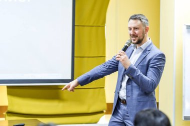 Siyasi toplantıda mikrofonlara konuşan iddialı erkek politikacı. Kürsüde konuşmacı