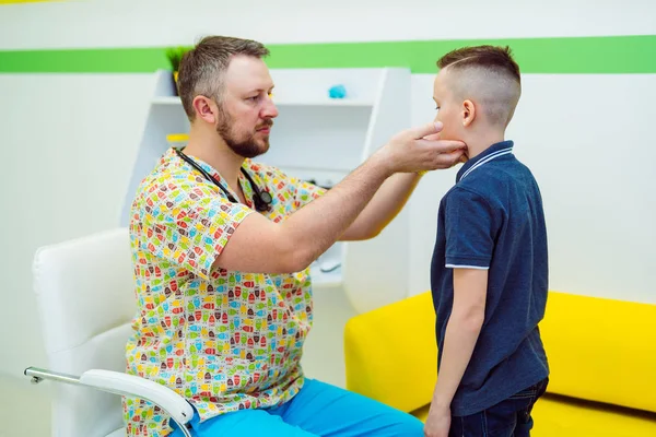 Il medico professionista controlla i linfonodi di un bambino in un centro medico. Il pediatra sta esaminando la gola infantile. Assistenza medica . — Foto Stock