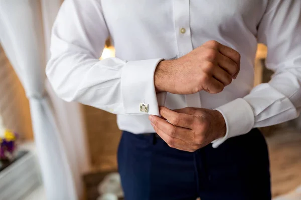 Um noivo vestindo abotoaduras enquanto ele se veste com roupas formais. Homem se preparando para o trabalho . — Fotografia de Stock