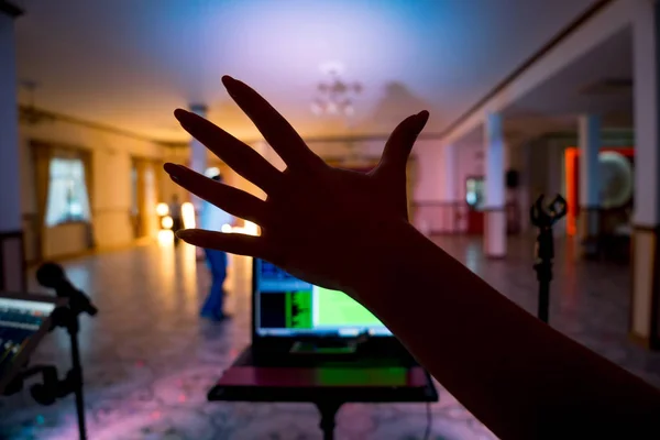 Vrouw de hand over de danszaal achtergrond. Opnamestudio mixer op digitale Tablet en microfoon op de onscherpe achtergrond. Close-up hand. — Stockfoto