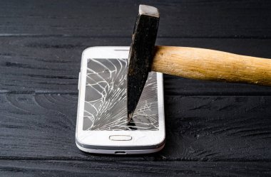 Koyu arka planda kırık ekrana sahip akıllı telefon. Close