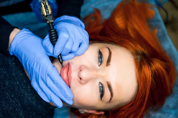 Здоровый спа: молодая красивая женщина с постоянной татуировкой макияжа на губах. Крупный план — стоковое фото