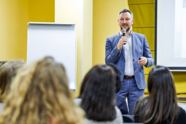 Konferans salonundaki izleyiciler. Seyirciler toplantıda bir yönetici sunumunu izliyor