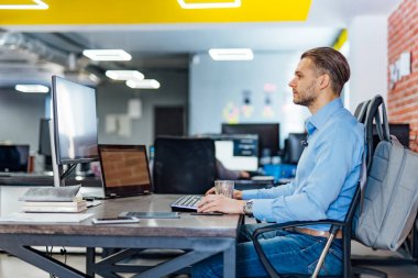 Birçok monitör ile masaüstü bilgisayarda çalışan erkek programcı