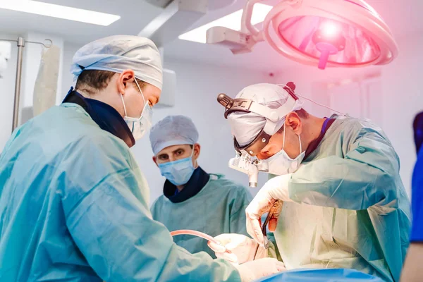 Командний хірург на роботі в операційній. Сучасне обладнання в операційній. Медичні пристрої для нейрохірургії . — стокове фото